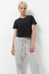 Babucha deportiva de algodón gris, con elástico en la cintura y puños ajustables, y dos bolsillos laterales.