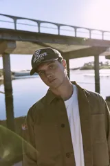 Gorra marrón de cinco paneles con bordado frontal con la inscripción "TT Archive Club Creative Dept. Established 1990".