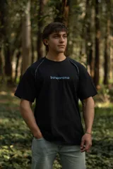 Remera negra de manga corta raglán, confeccionada en algodón. Presenta costuras a la vista y calce relajado.