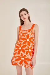 Vestido tejido con estampado de margaritas en jacquard color naranja, con ondas en el ruedo.