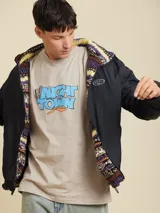 Campera con cierre frontal, cuello alto y bolsillos laterales. Tiene un logo pequeño de la marca en el pecho. Es reversible, con un lado liso y otro con estampado abstracto.