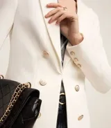 Blazer negro de punto roma con cuello solapa, cierre con ganchos, botones delanteros y forro de poliéster.