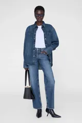 Camisa vaquera de denim azul con lavado mosaico, corte recto, cuello camisero, cierre frontal con botones a presión, mangas largas con puños abotonados, dos bolsillos de parche en el pecho y bajo redondeado. Marca Anine Bing.