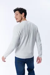 Buzo de punto color gris claro melange con textura acanalada.