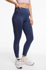 Calza deportiva larga negra con cintura alta, detalles de transparencias laterales en tul y bolsillos laterales.