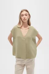 Blusa color verde oliva de poliéster, lisa, holgada y con cuello en V.