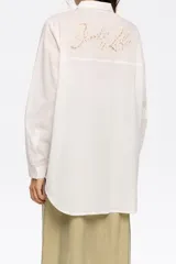 Camisa blanca de corte recto con cierre de botonadura frontal y cuello camisero. Manga larga con puños y botón, bolsillo de plastrón en el pecho y maxicanesú en espalda con logo bordado.