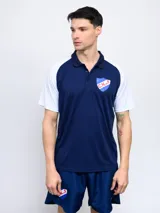 Remera polo de hombre con mangas cortas y cuello clásico. Diseño en color azul con mangas blancas y escudo del Club Nacional de Football bordado en el pecho.