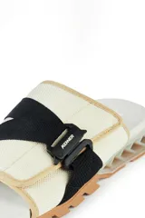 Sandalias Kenner Rakka Slide Pro color beige con detalles en negro y suela marrón.