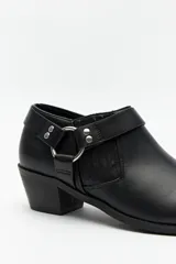 Botineta negra de cuero sintético con punta fina, taco bajo y apliques metálicos.