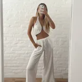 Pantalón blanco de tiro alto con corte palazzo y cordón ajustable en la cintura.
