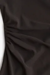 Vestido corto negro de malla con breteles spaghetti y escote drapeado. Tiene frunces en un lateral y forro de punto.