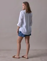 Camisa blanca de lino, marca Dash, con cuello con solapa, abertura central con botones, bolsillo aplicado en el pecho y mangas largas regulables con presilla y botón.