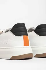 Zapatillas deportivas color verde militar con detalles en negro y beige. Presentan cordones negros, suela blanca y un rayo beige en el lateral.