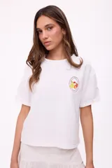 Remera blanca de algodón con cuello redondo y mangas cortas con dobladillo. Estampado pequeño en el pecho con logo de la marca y dibujo de frutas.