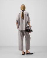 Camisa oversize color gris con manga corta japonesa sobre el codo, cuello solapa y botonadura frontal.