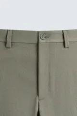Pantalón chino de vestir negro, corte slim fit, con bolsillos laterales y traseros. Cierre frontal con cremallera y botón.