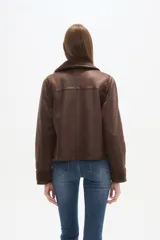 Campera marrón de poliéster con cuello y puños de corderito, cierre frontal y bolsillos laterales.