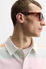 Polo de manga larga con cuello clásico y cierre de botones oculto. Diseño a rayas horizontales en colores azul, naranja, rosa y verde.