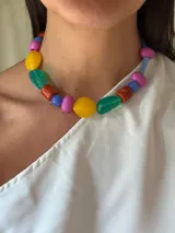 Collar corto con cuentas de cristal checo y acrílico de colores: rojo, azul, amarillo, verde y fucsia. Se cierra con cadena de acero quirúrgico y ganchito para regular el largo.