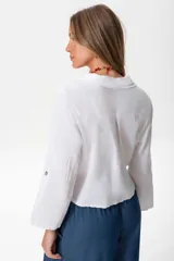 Camisa blanca de lino con mangas largas y cierre frontal con botones.