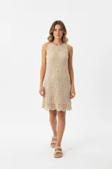 Vestido corto de crochet color beige, sin mangas y con cuello redondo.