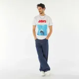 Remera blanca de manga corta con estampa de la película Tiburón (Jaws) en el frente.