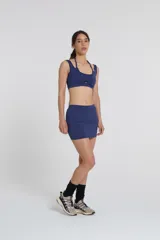 Top deportivo azul con doble escote superpuesto y cintura con elásticos. Confeccionado con textil Activelu con protección UV50+ y nula transparencia.