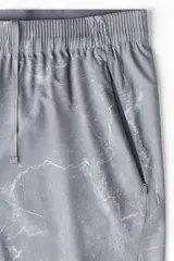 Short deportivo gris con estampado de mármol, de corte estándar, con cintura elástica y cordón de ajuste oculto, bolsillos laterales con cierre, orificios de ventilación cortados a láser y abertura lateral en el bajo.