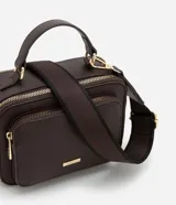 Bolso bandolera negro con correa de mano fija y asa larga ajustable desmontable. Cuenta con bolsillo delantero y cierre por cremallera.