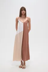 Vestido largo, holgado, con breteles finos y escote en V. Presenta un diseño de bloques de color en tonos blanco, beige claro y marrón.