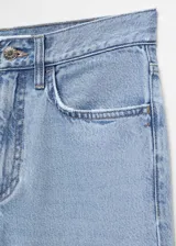 Pantalón de jean celeste de corte recto, tiro medio, con cinco bolsillos, trabillas y cierre de cremallera y botón.