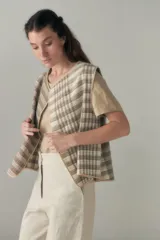 Chaleco marrón con solapas amplias y terminaciones envivadas. Diseño reversible y sin mangas.