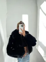 Campera corta de piel sintética negra con cierre metálico plateado.