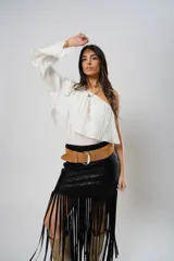 Blusa blanca con un hombro descubierto, manga larga con volados y textura arrugada.