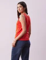 Musculosa tejida color fucsia de hilado fino, con cuello redondo y sisas amplias.