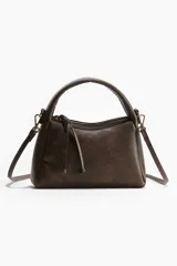 Cartera cruzada marrón con asa corta y correa extraíble.