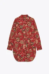 Camisa larga de algodón con estampado floral en tonos rojos, marrones y verdes. Tiene cuello solapa, manga larga con puños y bajo redondeado.