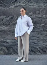 Camisa celeste a rayas verticales, de corte recto y manga larga con puños abotonados en blanco. Presenta cuello camisero blanco, cierre frontal con botones y un bolsillo de parche en el pecho.