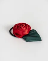 Gomita de pelo elástica con adorno de flor de tela roja y hojas verdes.