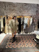 Ruana negra tejida a mano en lana merino con detalles de brillos y flecos.