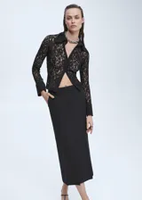 Falda midi de lana color negro, de corte recto y tiro alto, con abertura frontal, cierre trasero con cremallera y gancho, y forro interior.