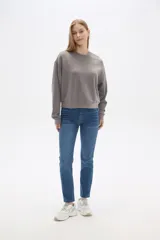 Buzo color beige de corte ancho y cuello redondo.