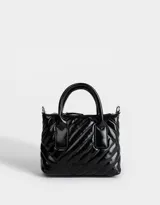 Cartera city negra acolchada con efecto craquelado, asas cortas de mano y correa larga regulable desmontable.