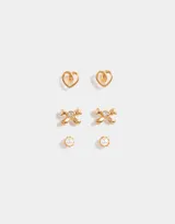 Set de tres pares de aros dorados: un par con forma de corazón, un par con forma de moño con strass y un par con forma de perla.