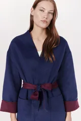 Tapado azul marino con cuello en V, mangas largas con puños en color borgoña y cinturón de lazo borgoña.