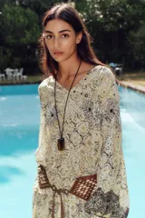 Blusa estampada con hilo metalizado, cuello redondo con volante, escote pico y manga larga abullonada.