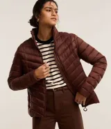 Campera puffer ultraligera color marrón, confeccionada en poliamida acolchada, con cuello alto y cierre por cremallera. Incluye bolsita con cordón.