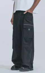 Pantalón cargo negro de corte oversize, con cintura elástica, múltiples bolsillos y confeccionado en tejido liviano 100% poliéster.