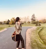 Bolso de viaje grande de cuero vacuno color negro con detalles en marrón. Tiene herrajes metálicos, gran superficie interna, asa de mano y correa para el hombro.